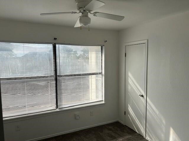 1737 Liberty Ln, Mesquite, TX 75149 - spare room featuring ceiling fan, dark colored carpet, and plenty of natural light