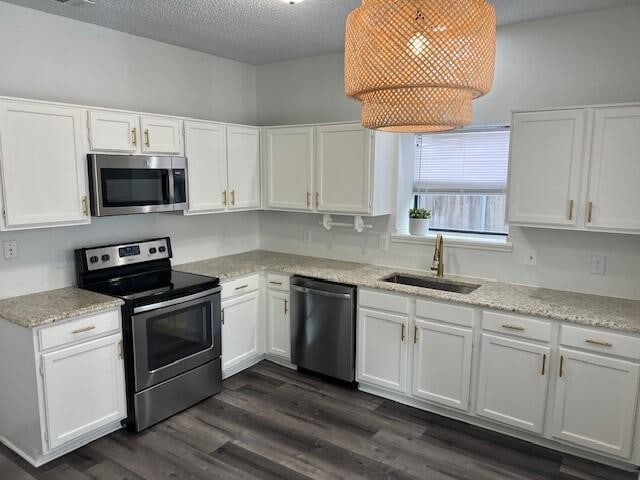 1737 Liberty Ln, Mesquite, TX 75149 - kitchen featuring stainless steel appliances, a sink, white cabinetry, a textured ceiling, and dark wood-type flooring