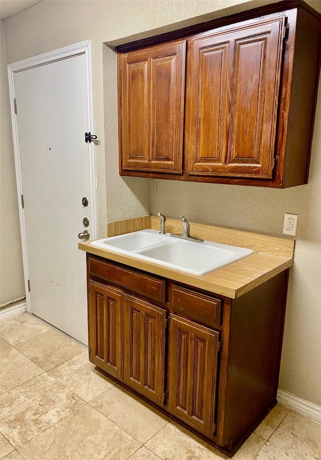 2512 Lawndale Dr, Plano, TX 75023 - kitchen with a sink, light countertops, a textured wall, and light tile patterned flooring