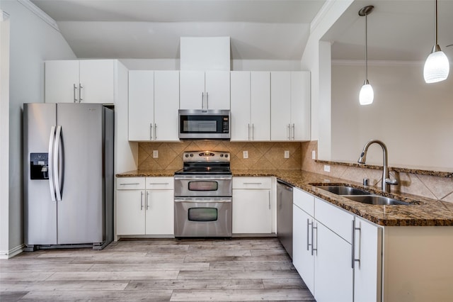 393 Bluebird Ln, Fairview, TX 75069 - kitchen with stainless steel appliances, a sink, dark stone counters, white cabinets, and crown molding