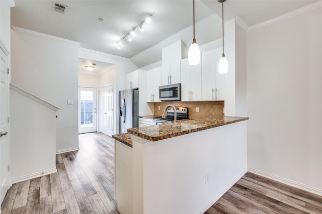 393 Bluebird Ln, Fairview, TX 75069 - kitchen with appliances with stainless steel finishes, tasteful backsplash, light wood finished floors, white cabinets, and pendant lighting