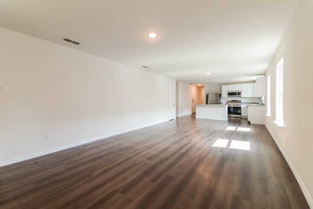 471 Bobbie St, Mabank, TX 75147 - unfurnished living room with dark wood-type flooring, recessed lighting, baseboards, and a sink