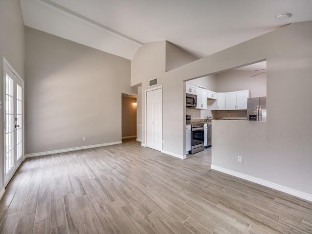 4241 Malone Ave, The Colony, TX 75056 - unfurnished living room with high vaulted ceiling, baseboards, and light wood-style flooring