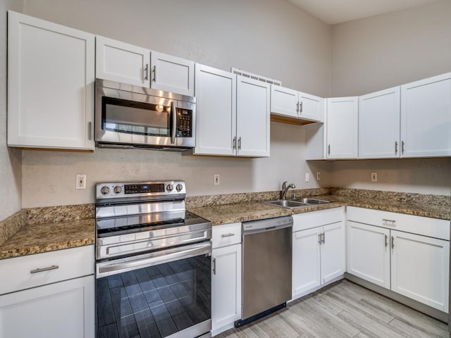 4241 Malone Ave, The Colony, TX 75056 - kitchen featuring stainless steel appliances, a sink, white cabinetry, and light wood finished floors