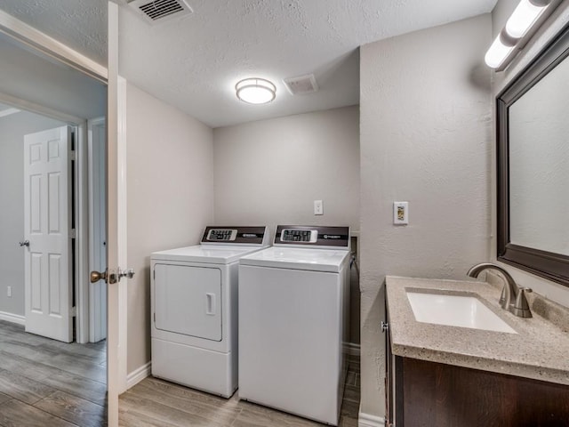 4241 Malone Ave, The Colony, TX 75056 - washroom with independent washer and dryer, light wood-style flooring, baseboards, and a textured ceiling