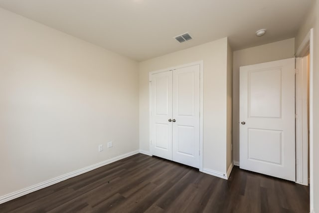825 Garrison St, Waco, TX 76704 - unfurnished bedroom with dark wood-style floors, baseboards, and a closet