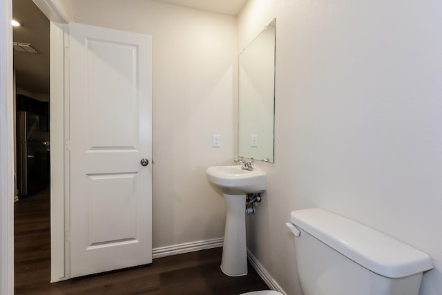 825 Garrison St, Waco, TX 76704 - half bath featuring wood finished floors, toilet, and baseboards