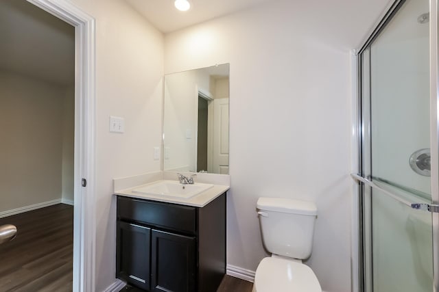 825 Garrison St, Waco, TX 76704 - full bath with wood finished floors, toilet, vanity, an enclosed shower, and baseboards