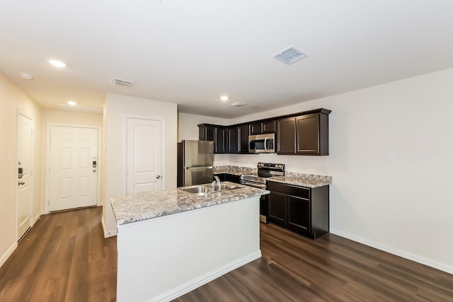 825 Garrison St, Waco, TX 76704 - kitchen with appliances with stainless steel finishes, a sink, dark wood finished floors, recessed lighting, and an island with sink