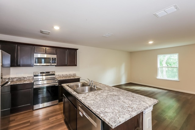 825 Garrison St, Waco, TX 76704 - kitchen with stainless steel appliances, a sink, dark wood-style flooring, a kitchen island with sink, and dark brown cabinetry