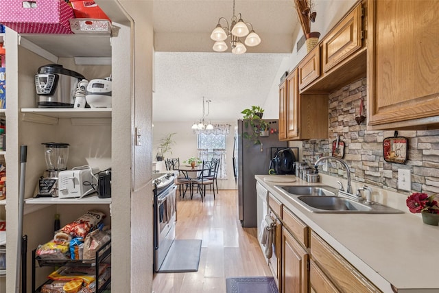 1005 Blue Jay Dr, Mansfield, TX 76063 - kitchen with a chandelier, electric range, light wood-type flooring, light countertops, and brown cabinetry