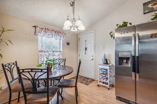 1005 Blue Jay Dr, Mansfield, TX 76063 - dining space featuring a textured ceiling, a chandelier, light wood-type flooring, and vaulted ceiling