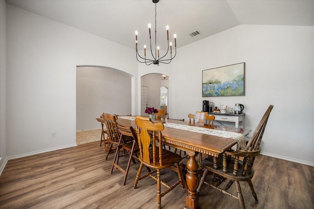 800 Bur Oak Dr, Burleson, TX 76028 - dining area featuring arched walkways, lofted ceiling, wood finished floors, a chandelier, and baseboards