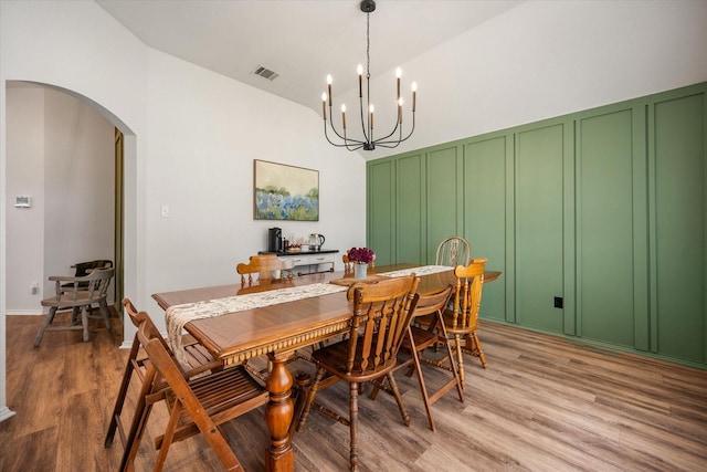 800 Bur Oak Dr, Burleson, TX 76028 - dining space with arched walkways, light wood-type flooring, a chandelier, a decorative wall, and lofted ceiling