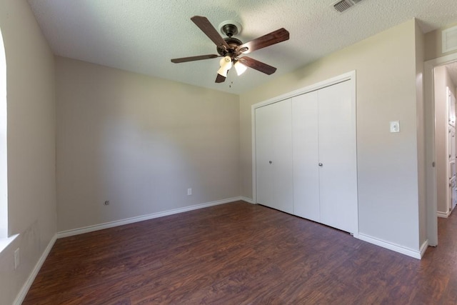 4501 Mink Dr, Haltom City, TX 76117 - unfurnished bedroom featuring wood finished floors, a textured ceiling, a closet, baseboards, and a ceiling fan