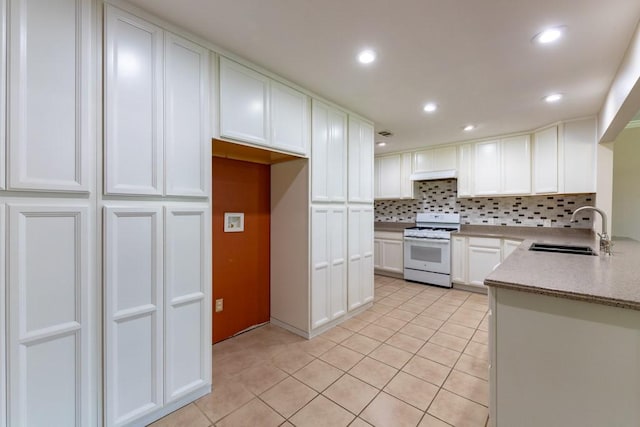 4501 Mink Dr, Haltom City, TX 76117 - kitchen featuring white range with gas stovetop, a sink, light tile patterned floors, tasteful backsplash, and white cabinetry