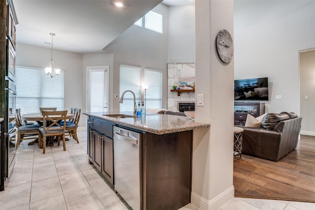 1225 Horsemint Dr, Little Elm, TX 75068 - kitchen with a sink, dishwasher, a stone fireplace, open floor plan, and light stone counters