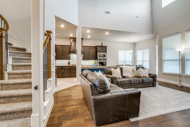 1225 Horsemint Dr, Little Elm, TX 75068 - living room with stairs, dark wood-style floors, a towering ceiling, recessed lighting, and a chandelier