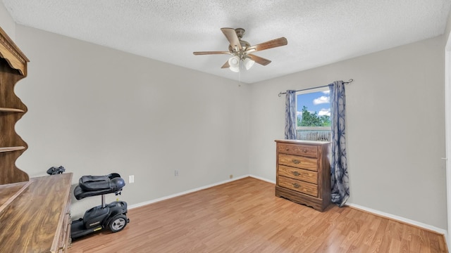 239 N 10th St, Jacksboro, TX 76458 - unfurnished bedroom featuring light wood-type flooring, a textured ceiling, baseboards, and ceiling fan