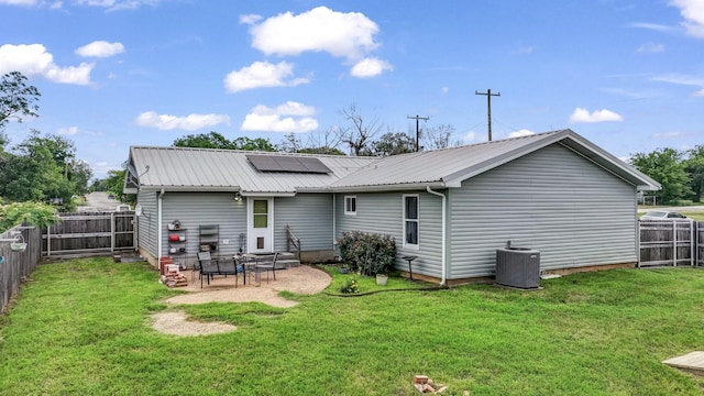 239 N 10th St, Jacksboro, TX 76458 - rear view of house featuring solar panels, central AC, metal roof, and a patio