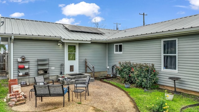 239 N 10th St, Jacksboro, TX 76458 - back of house with a patio, metal roof, and roof mounted solar panels