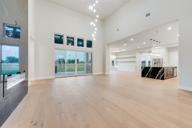 1700 Hamilton Ln, Northlake, TX 76247 - unfurnished living room with light wood-type flooring, a high ceiling, baseboards, and recessed lighting