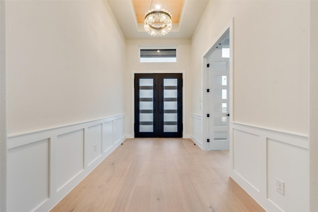 1700 Hamilton Ln, Northlake, TX 76247 - foyer entrance featuring a chandelier, a decorative wall, light wood-type flooring, wainscoting, and a tray ceiling