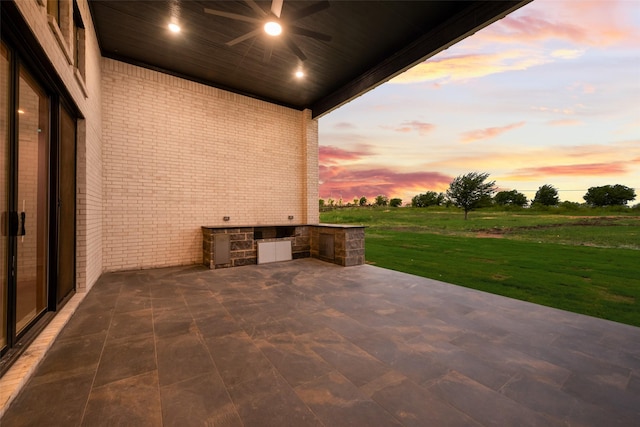 1700 Hamilton Ln, Northlake, TX 76247 - patio terrace at dusk featuring an outdoor kitchen, a ceiling fan, a patio, and a lawn