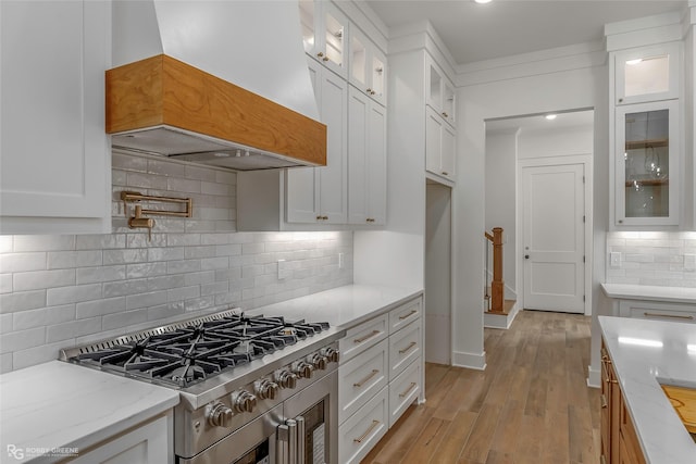39 Turtle Creek Dr, Benton, LA 71006 - kitchen with stove, custom range hood, backsplash, white cabinetry, and light stone counters