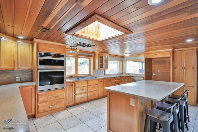 920 SW 3rd St, Hamlin, TX 79520 - kitchen featuring wooden ceiling, appliances with stainless steel finishes, light tile patterned floors, a center island, and backsplash