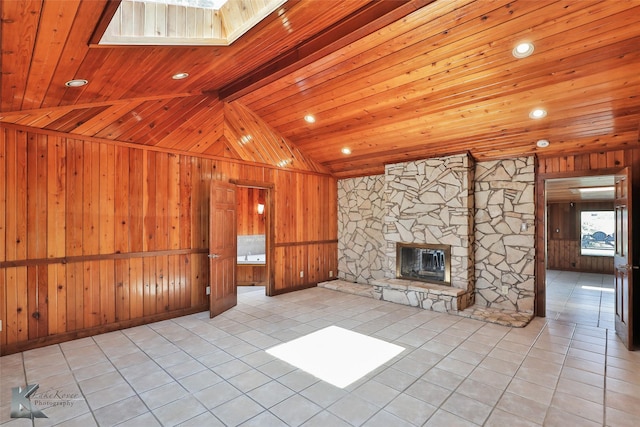 920 SW 3rd St, Hamlin, TX 79520 - unfurnished living room featuring wooden walls, wooden ceiling, tile patterned floors, a skylight, and a stone fireplace
