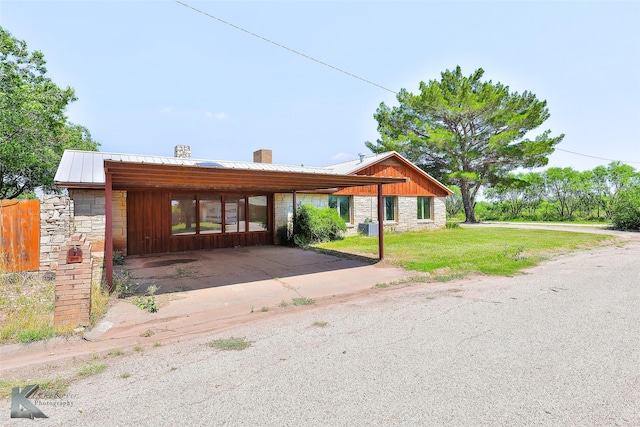 920 SW 3rd St, Hamlin, TX 79520 - view of front of house featuring stone siding, a chimney, a front yard, and metal roof