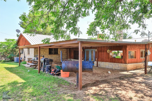 920 SW 3rd St, Hamlin, TX 79520 - back of property featuring central air condition unit, board and batten siding, a lawn, and metal roof