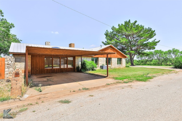 920 SW 3rd St, Hamlin, TX 79520 - view of front of house with stone siding, a chimney, a front yard, and metal roof