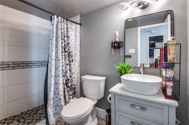 3232 Bunker Hill Dr, Forest Hill, TX 76140 - bathroom featuring a textured wall, vanity, a tile shower, toilet, and a textured ceiling