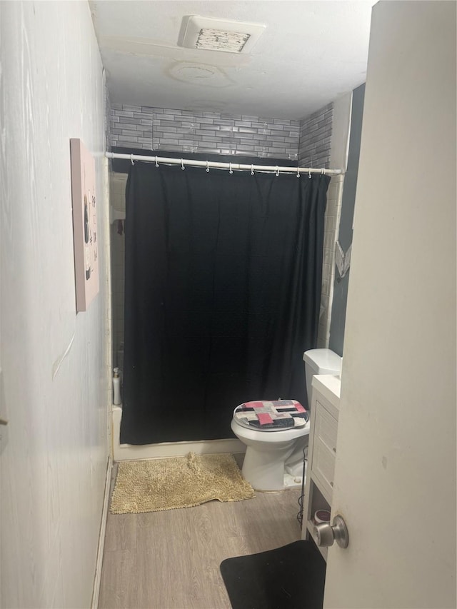 1213 Southridge Dr, Lancaster, TX 75146 - full bath with wood finished floors, a shower with curtain, toilet, and vanity