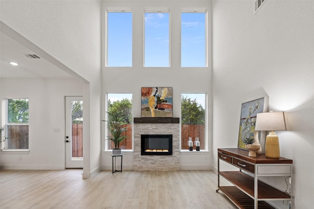 5634 Barkridge Dr, Granbury, TX 76048 - living area featuring wood finished floors, a fireplace, a towering ceiling, and baseboards