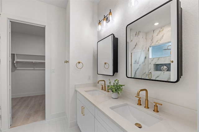 5634 Barkridge Dr, Granbury, TX 76048 - bathroom featuring double vanity, a marble finish shower, baseboards, and a walk in closet