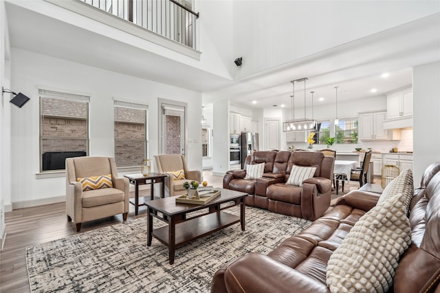 12947 Cabana Dr, Frisco, TX 75035 - living room with light wood-type flooring, recessed lighting, and a towering ceiling
