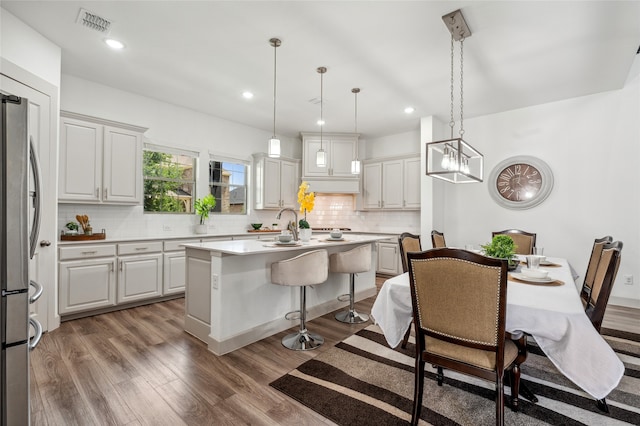 12947 Cabana Dr, Frisco, TX 75035 - kitchen featuring freestanding refrigerator, wood finished floors, backsplash, a center island, and recessed lighting