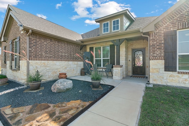 1052 Winecup Ln, Weatherford, TX 76085 - property entrance featuring stone siding, roof with shingles, brick siding, and a porch