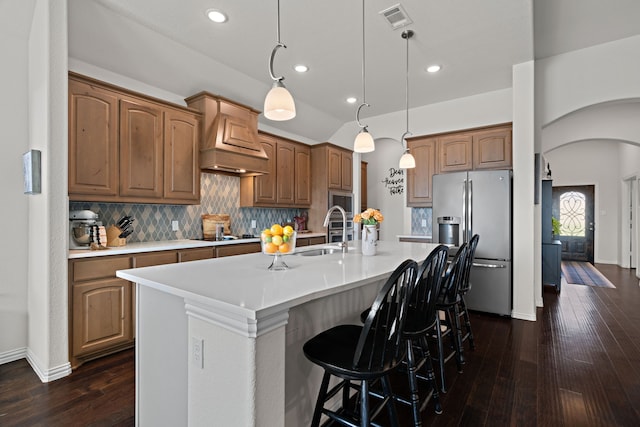 1052 Winecup Ln, Weatherford, TX 76085 - kitchen with appliances with stainless steel finishes, a sink, arched walkways, dark wood-style floors, and a kitchen island with sink