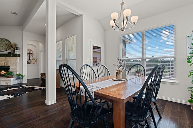 1052 Winecup Ln, Weatherford, TX 76085 - dining area with dark wood-style floors, arched walkways, baseboards, a chandelier, and a fireplace