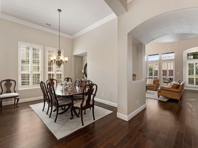 1025 Arches Park Dr, Allen, TX 75013 - dining room featuring arched walkways, baseboards, a chandelier, crown molding, and dark wood-type flooring