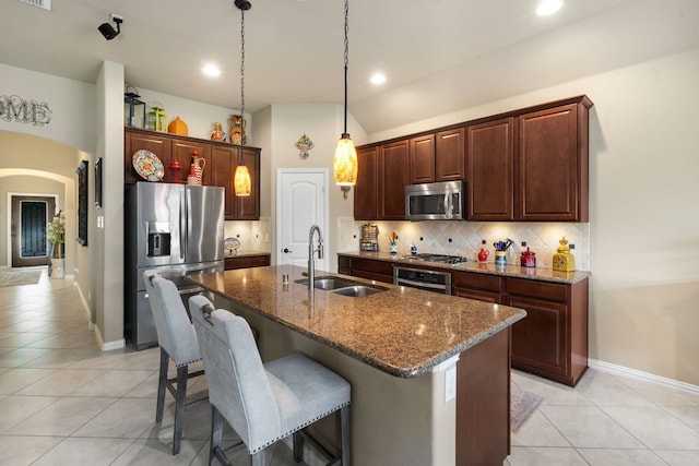 1129 Mesa Crest Dr, Fort Worth, TX 76052 - kitchen featuring appliances with stainless steel finishes, a sink, light tile patterned flooring, decorative backsplash, and an island with sink