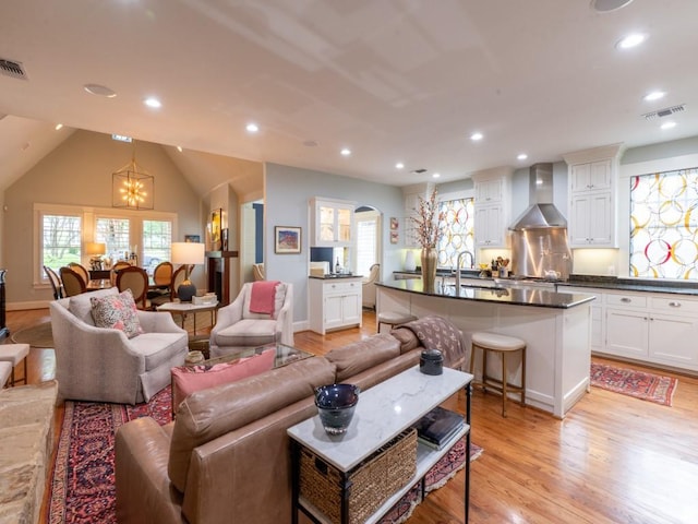6319 Mccommas Blvd, Dallas, TX 75214 - living room with a chandelier, light wood finished floors, recessed lighting, baseboards, and arched walkways