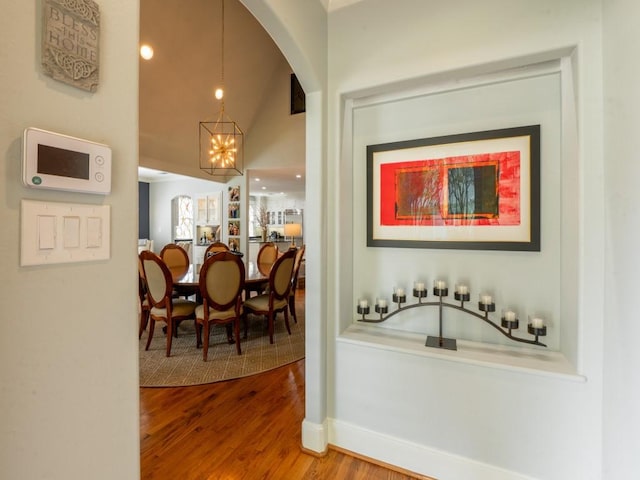 6319 Mccommas Blvd, Dallas, TX 75214 - bar with wood finished floors, a chandelier, arched walkways, baseboards, and vaulted ceiling