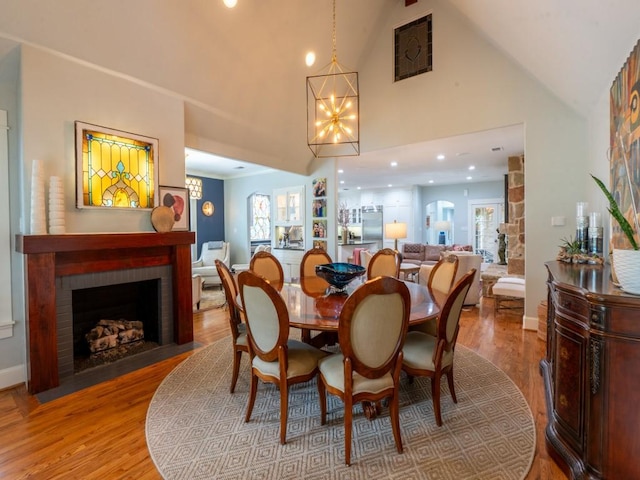 6319 Mccommas Blvd, Dallas, TX 75214 - dining room featuring a chandelier, a fireplace, wood finished floors, baseboards, and high vaulted ceiling