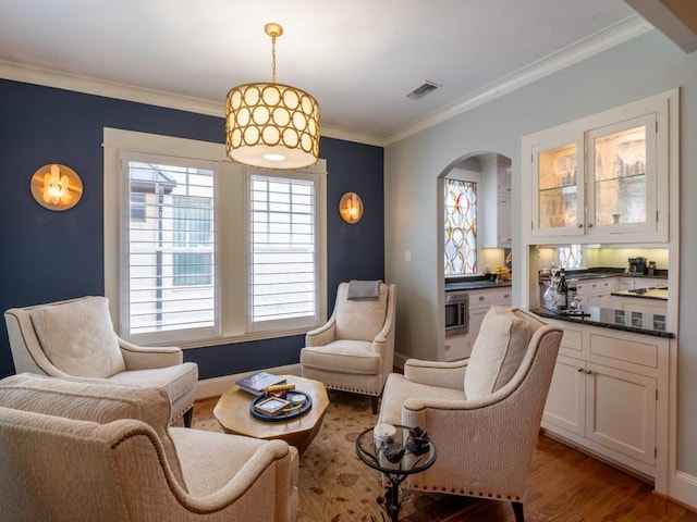 6319 Mccommas Blvd, Dallas, TX 75214 - sitting room featuring arched walkways, wood finished floors, and crown molding