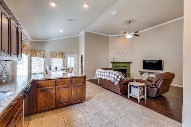 5825 Loveland Dr, Denton, TX 76208 - kitchen with open floor plan, dishwashing machine, a lit fireplace, a peninsula, and ornamental molding
